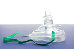 CPR one-way mask for first aid kit on a blue surface, showing the clear design and green strap.