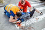 First responders assist an injured person in the street, emphasizing the importance of QuikClot wound care innovations.