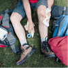 Trailside Heroes: Mastering First Aid for Cuts, Scrapes, and Wounds being applied on a wounded leg outdoors.