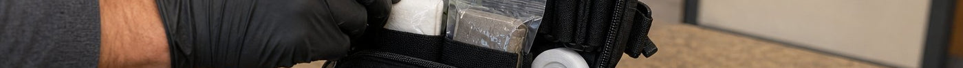 Open bleed control kit showing tourniquets, gauze, chest seals, and gloves laid out for inspection — components guide for public access readiness
