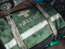 Tactical first aid kits vs everyday carry showing a green first aid bag with straps.