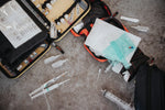 vehicle trauma kits for road trips with medical supplies scattered on a concrete floor.