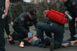 Emergency responders practicing preventing blood loss in emergencies with a tourniquet and hemostatic dressings.