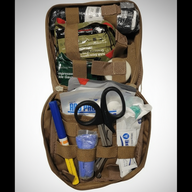 Open Enhanced Individual First Aid Kit showing medical supplies, scissors, and trauma essentials.