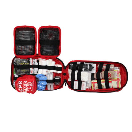 Open tactical trauma kit showing red pouch filled with medical supplies, including bandages and a CPR mask.