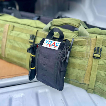 ViTAC Tactical Individual First Aid Kit attached to a green tactical bag in a vehicle.