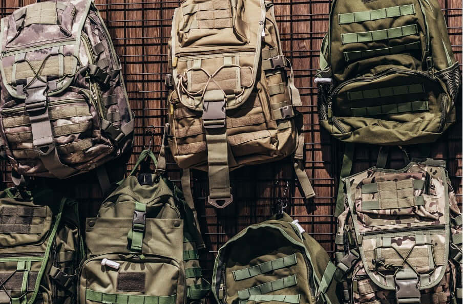 Variety of tactical backpacks displayed on a wall, showcasing essential gear for professionals and prepared citizens.