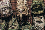 Variety of tactical backpacks displayed on a wall, showcasing essential gear for professionals and prepared citizens.