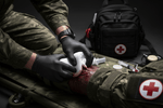 How Hemostatic Gauze Can Help Save Lives in a Bleeding Emergency - soldier applying first aid to a bleeding injury.
