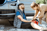 The Critical Role of Emergency Trauma Dressings in first aid for a man injured in an accident, receiving help.