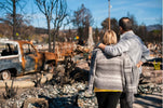 Ultimate Guide to Building a Home Emergency Preparedness Kit shows a couple surveying damaged property after a disaster.