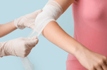 Demonstration of compressed gauze wound packing techniques on an injured arm for hemorrhage control.
