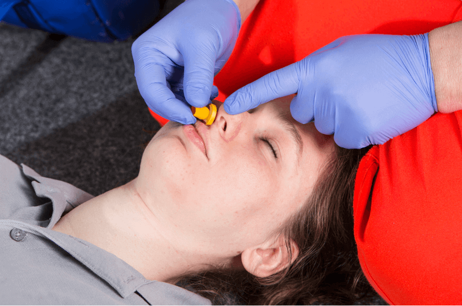 Demonstrating nasopharyngeal airway management technique during emergency response training session.