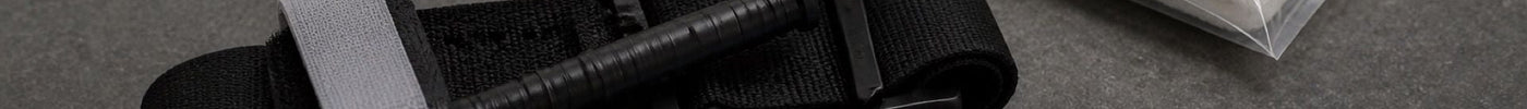 CAT Gen 7 windlass tourniquet and SOFTT-W tourniquet staged on dark tactical surface for comparison
