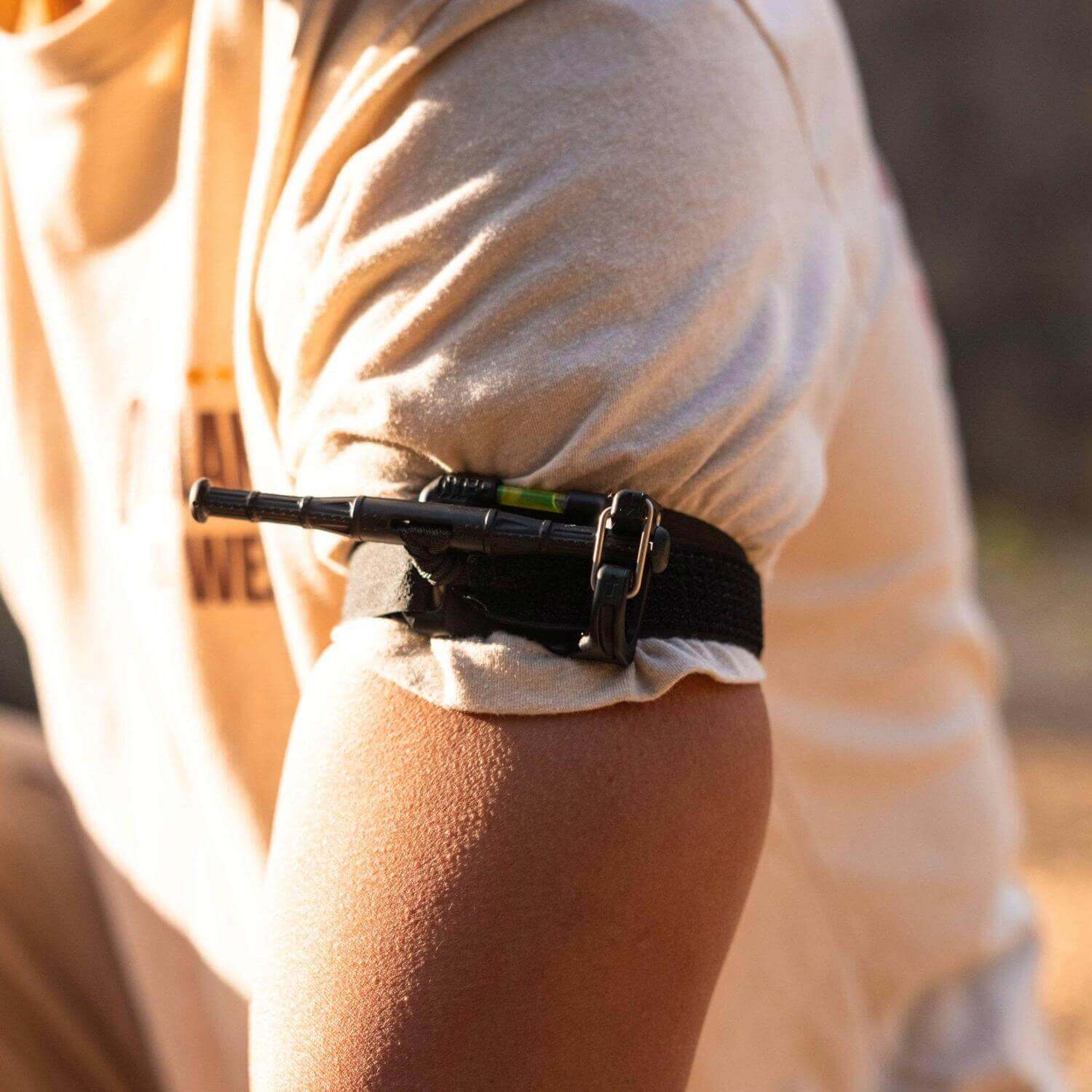 Tourniquet for camping and hiking applied to an arm, demonstrating emergency first aid techniques outdoors.