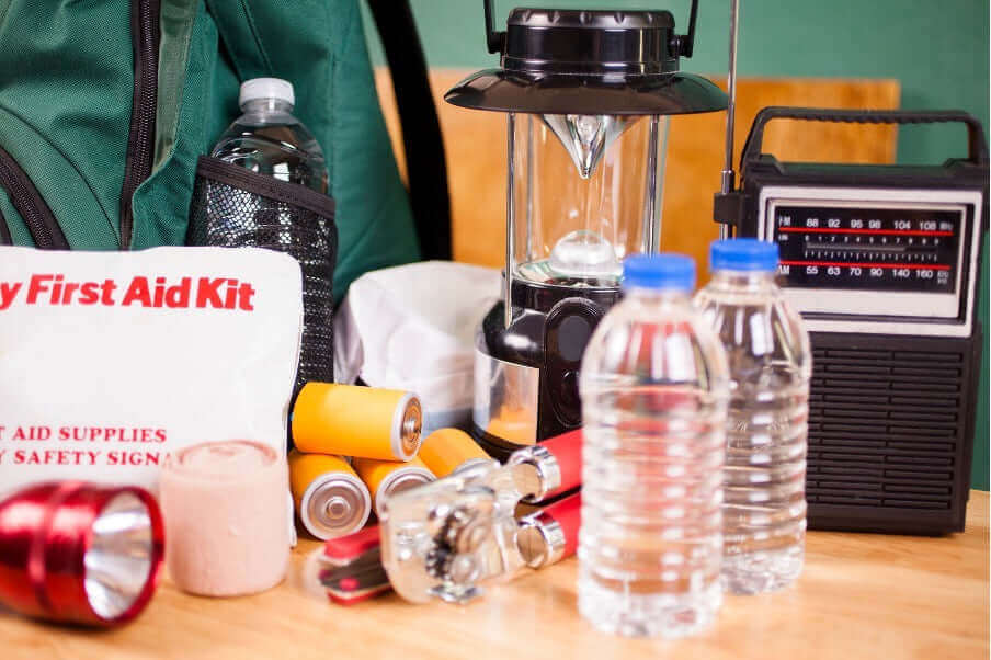 Teaching Preparedness: A collection of emergency supplies including a first aid kit, water bottles, and a lantern.