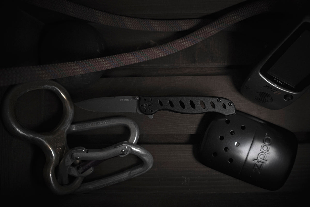 An assortment of tools including a knife and carabiners for law enforcement trauma kit configurations.