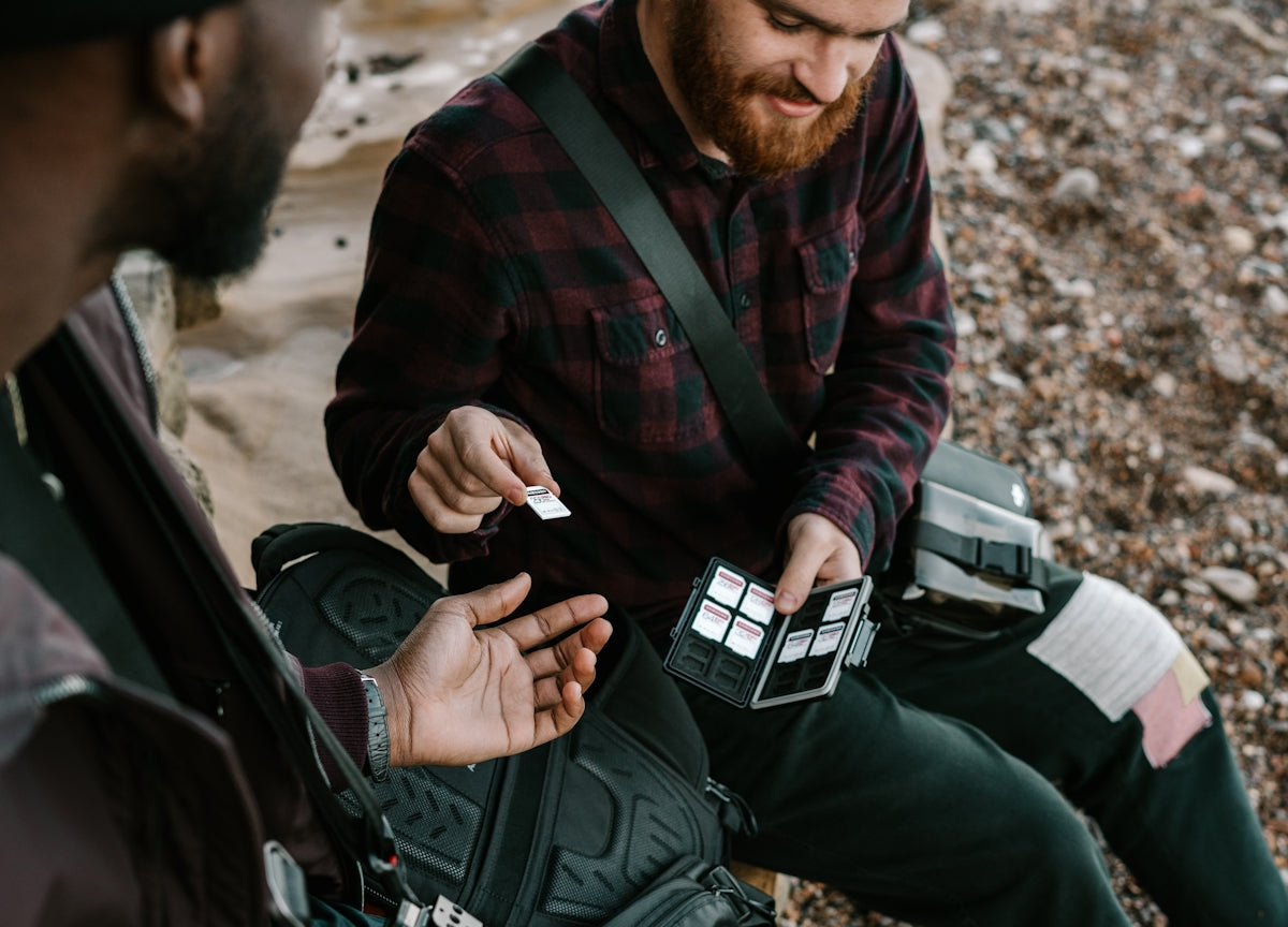 Two individuals sharing items, highlighting the importance of TCCC compliant individual first aid kit for emergencies.