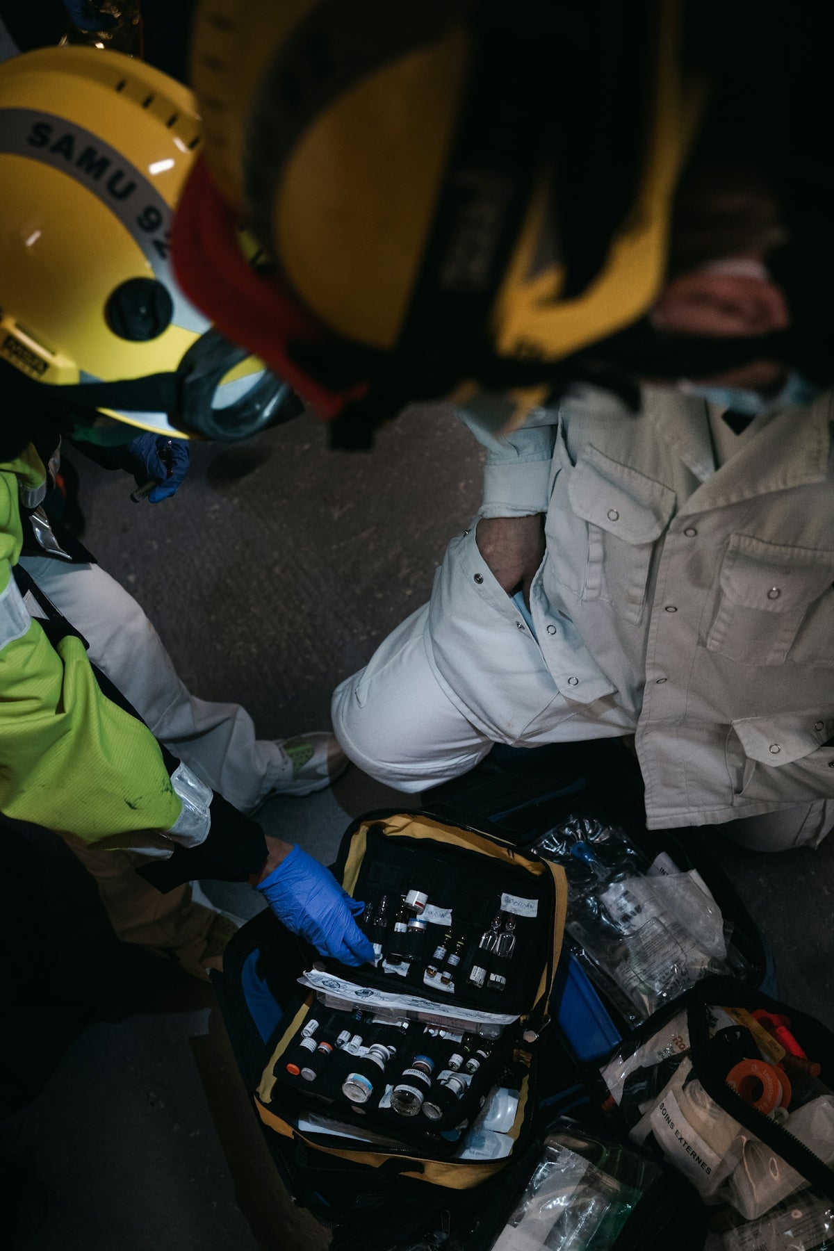 Emergency personnel reviewing a family first aid kit selection during a crisis.