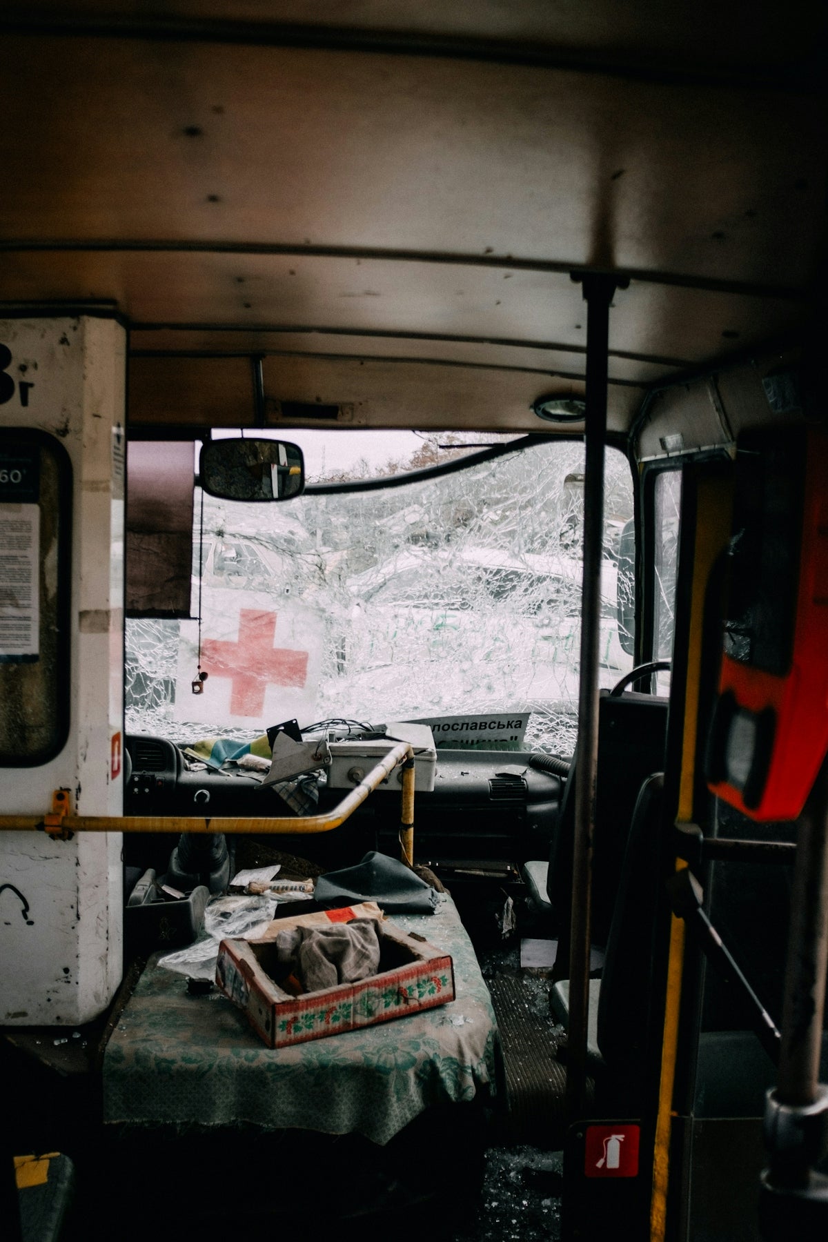 Interior of a damaged vehicle with first aid supplies, emphasizing the need for hemostatic agents for severe bleeding.
