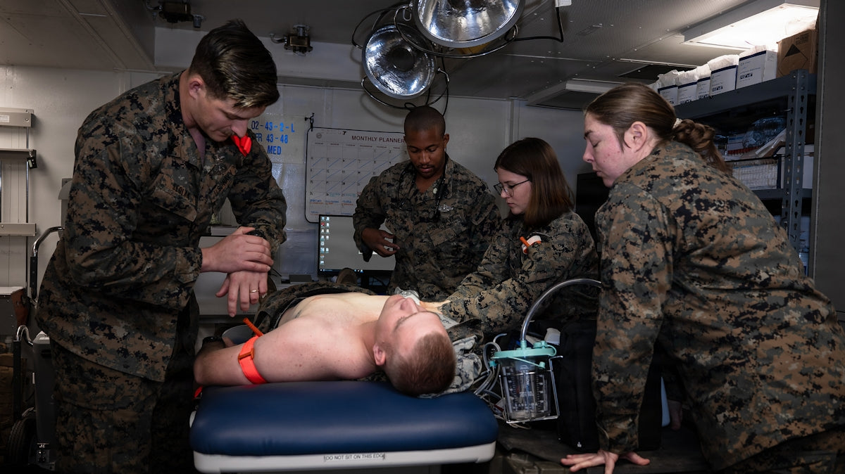 Soldiers providing medical care using a tactical IFAK trauma kit in a military setting.