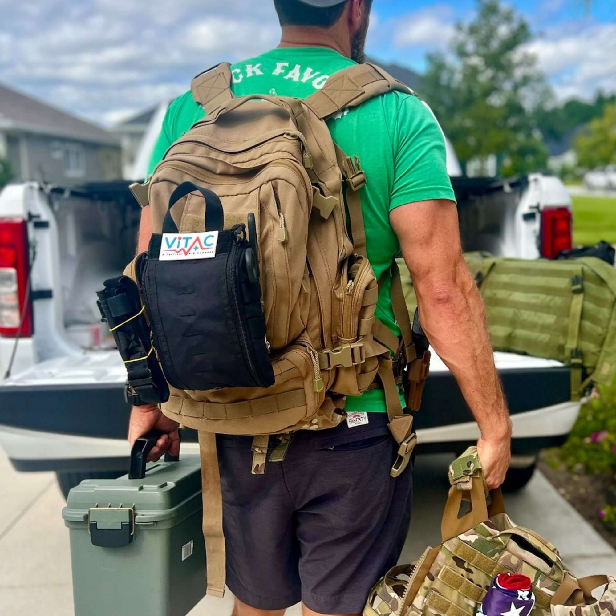 Man carrying Trauma & First Aid Backpacks and gear, preparing for rescue operations outdoors.
