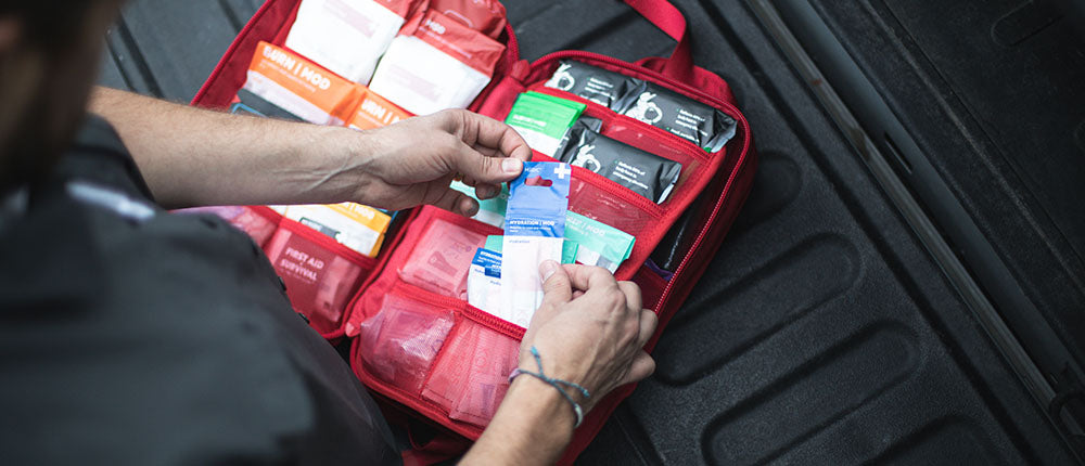 Person organizing items in the MyFAK Large Medical Kit by MyMedic, showing various medical supplies.