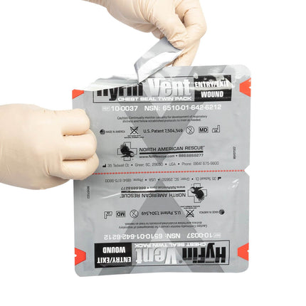 Person opening the HyFin Vented Chest Seal Twin Pack for chest trauma treatment.
