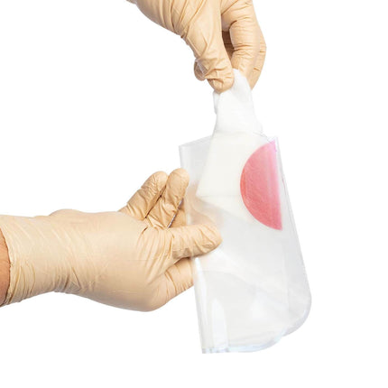 Person in gloves holds the HyFin Vented Chest Seal, ready for application, showcasing its packaging.