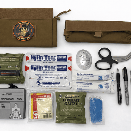 First aid kit with various supplies including bandages, scissors, and a pen on a white background