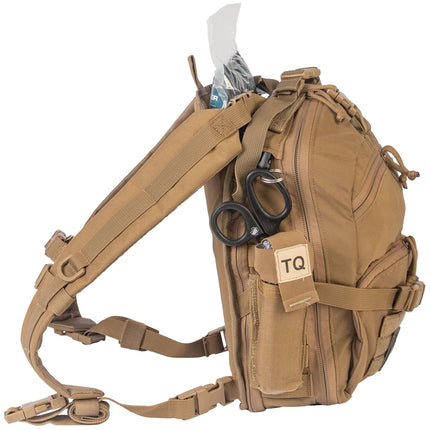 Tan tactical backpack with various items on a white background