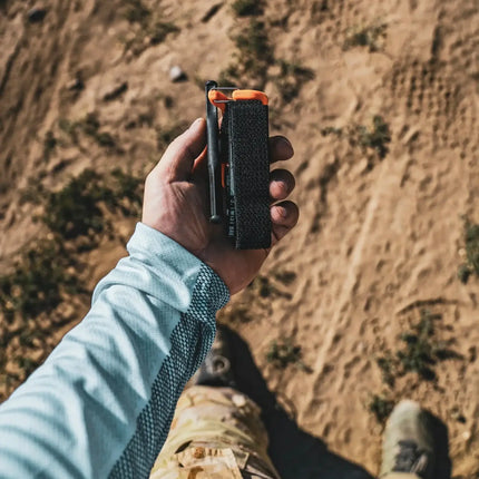 Person holding Snakestaff Systems Everyday Carry Tourniquet (ETQ™) GEN 2 in a desert setting.