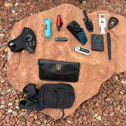 The Stay Safe Self Defense Kit featuring tools on a rock, including a personal alarm, tactical pen, and hotel lock.
