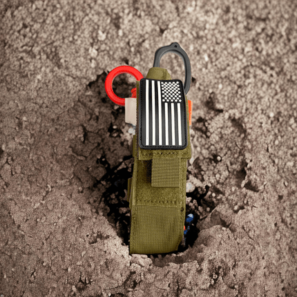 ONE SHEAR First Response TQ Holster, a tourniquet holster for first responders, secured in gravel.