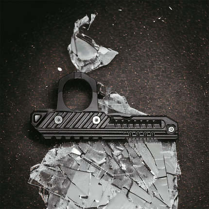 3-in-1 rescue tool on a surface with broken glass, showcasing its design and functionality for emergencies.