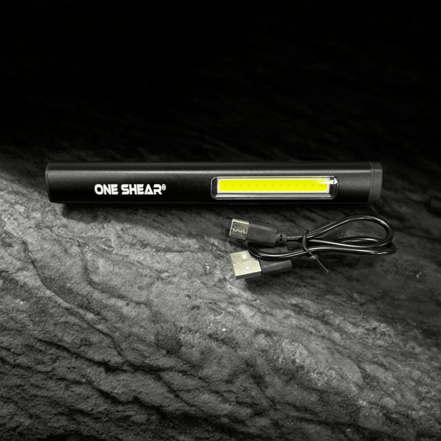 ONE SHEAR XPE+COB Magnetic Penlight with USB charging cable on a dark background.