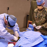 Telementored_Surgery_Demo_inguinal_artery_surgical_access_Lcdr_Carl_Long_PA_and_18D_SFC_Paul_Loos_running_anesthesia.jpg__PID:e58d53e8-b5be-4c0b-be14-c7432a57c2e3