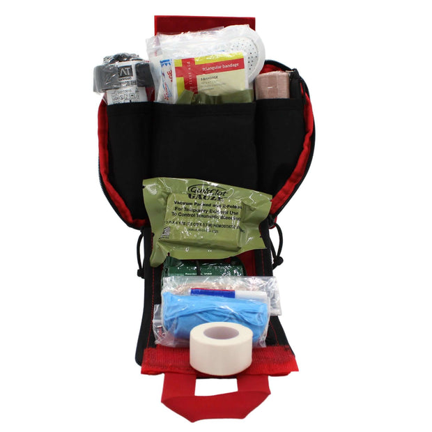 Tactical Individual First Aid Kit (IFAK) open, displaying medical supplies including bandages, tape, and dressings.