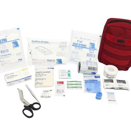 Compact IFAK contents including bandages, scissors, and medical supplies for first aid.
