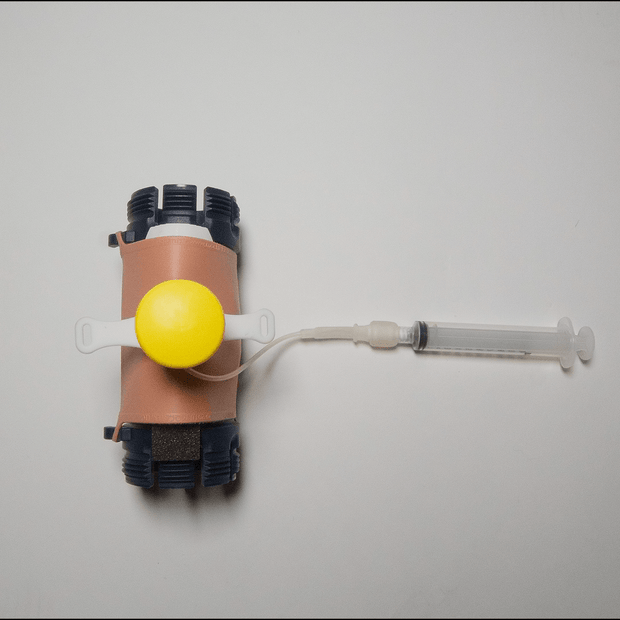 MITS Composite Trainer Kit showing a portable multi-skill trainer with syringe for practicing needle insertion skills.
