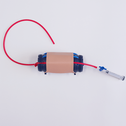 MITS Composite Trainer Kit showing portable training device with tubing and connectors for needle insertion practice.