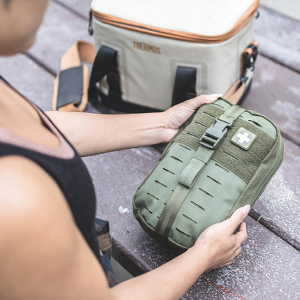 A person holding the MyFAK First Aid Kit, compact and portable for emergency medical needs.